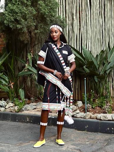 Woman in black attire with beaded headband, wristbands and patterned trim