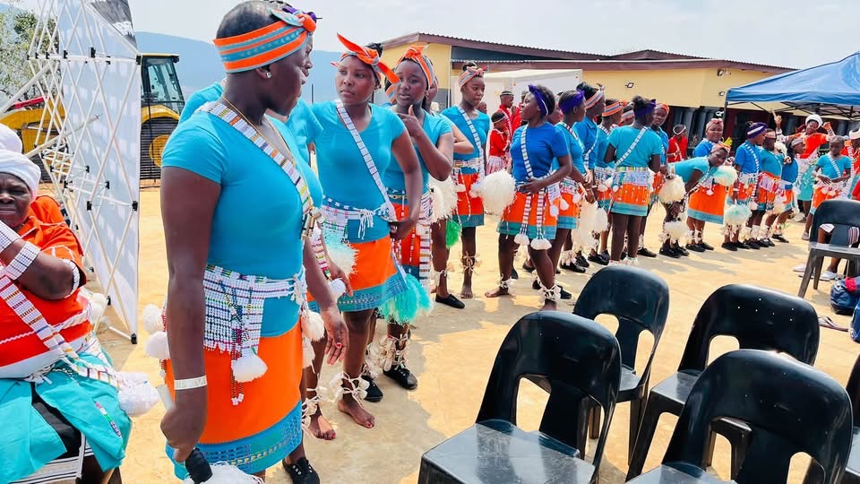 A group of women in blue and orange dress with beaded accessories